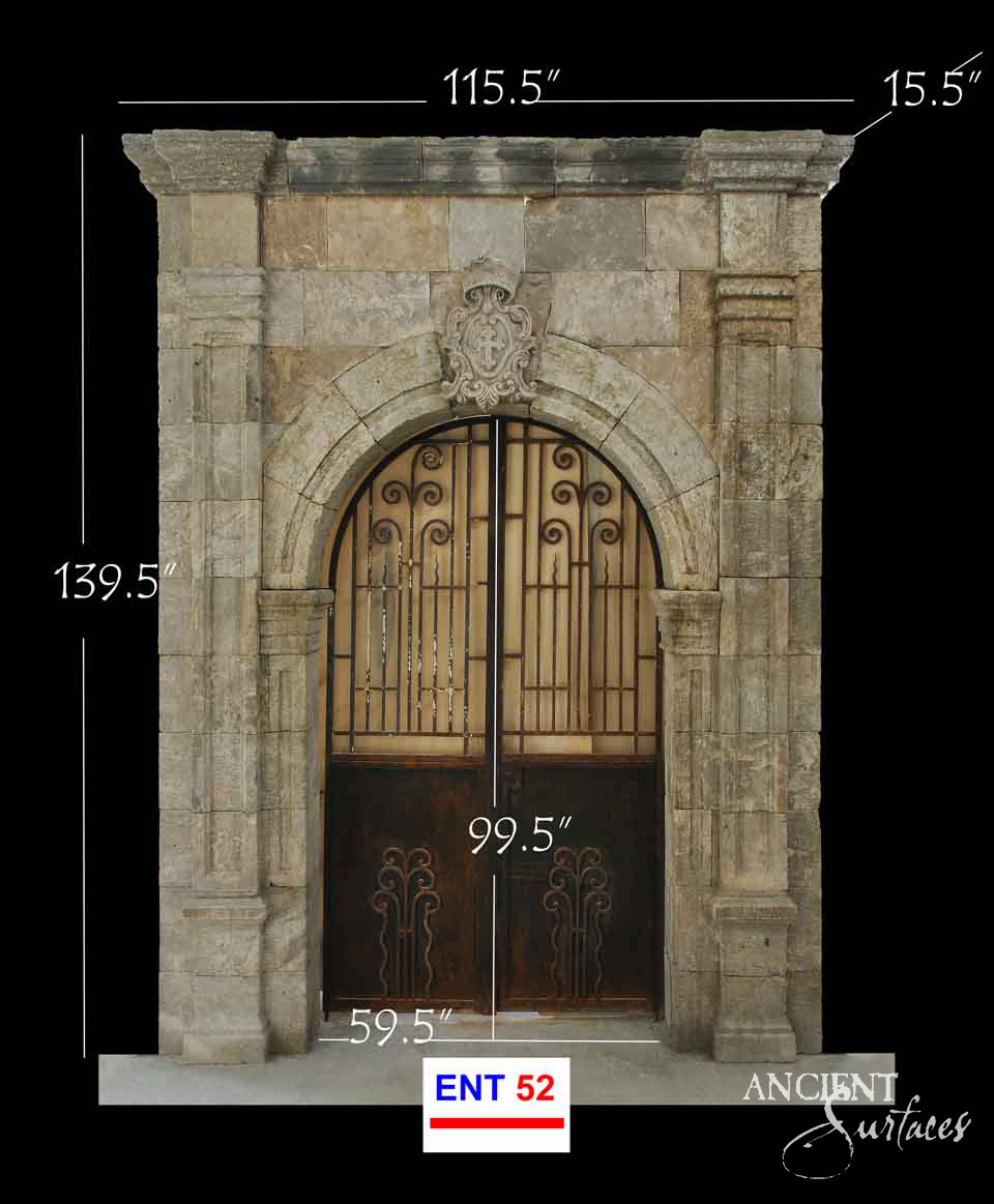 Reclaimed antique limestone entryway from Ancient Surfaces with a carved shield cartouche above a rounded arch and fluted pilasters, photographed with dealer measurements marked, code ENT 52