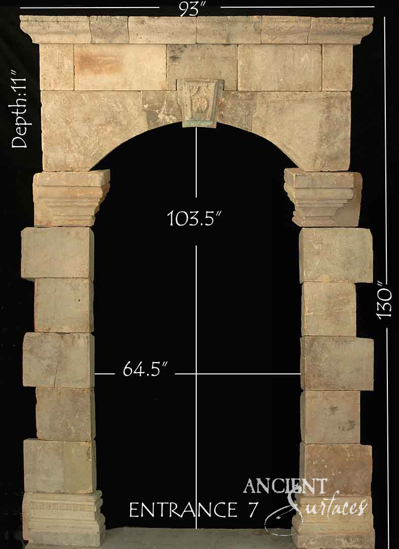 Reclaimed antique limestone entryway from Ancient Surfaces built from rough tumbled ashlar blocks with a carved rosette keystone, photographed with dealer measurements marked, code Entrance 7